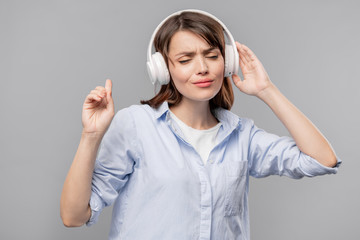 Young brunette female in headphones enjoying her favorite music