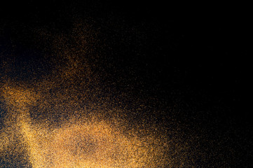 Fototapeta na wymiar Black background with golden sparkles. Blurred effect