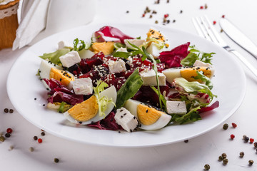 Fresh mixed salad in a bowl on a white background