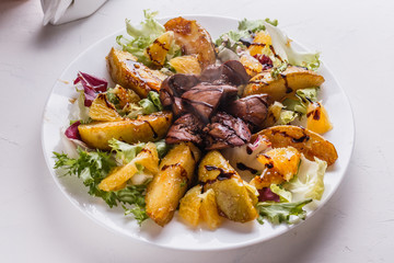 Baked potatoes with boiled chicken liver on a plate
