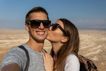 young couple taking a selfie in the desert of israel