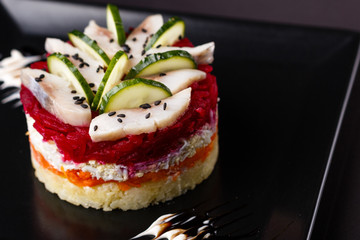 Russian salad herring under fur coat on a dark background