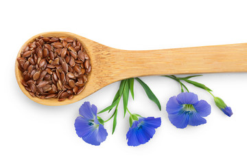 flax seeds in wooden spoon with flower isolated on white background