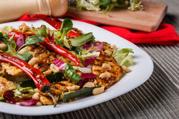 Mexican salad with hot pepper chiken fillet lettuce on plate