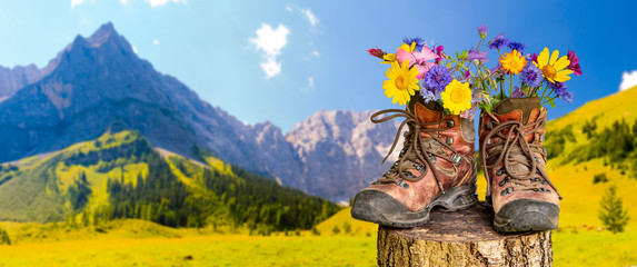 Wanderschuhe mit Blumen in schöner bayerischer Landschaft