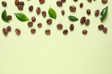 Fresh green coffee leaves and beans on light green background, flat lay. Space for text