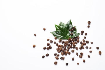 Fresh green coffee leaves and beans on white background, top view