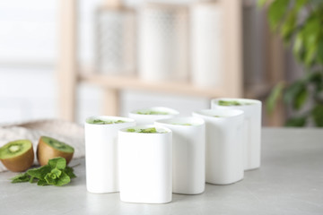 Cups for homemade yogurt and fresh kiwi on table in kitchen. Recipe for multi cooker