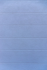 Ausschnitt Fassade als Hintergrund eines Hauses mit blauem Verputz und horizontal verlaufenden Sichtfugen als Gestaltungselement