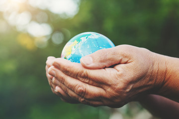 world environment day, senior woman's hands holding earth globe