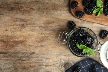 Flat lay composition with tasty blackberries and space for text on wooden table