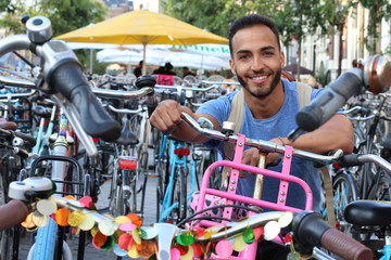 Fototapeta na wymiar Handsome ethnic man in bicycle parking lot
