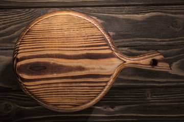 top view of wooden cutting board on brown table