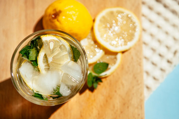 Glass of lemonade drink or Mojito cocktail with lemon, mint and ice from top view