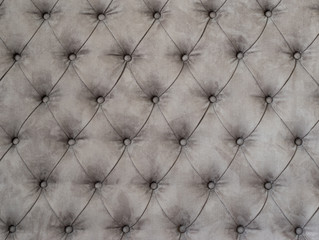 Grey textile background with stitched buttons.