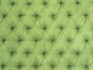 Green abstract background with symmetrical upholstered buttons on fabrics.