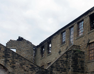 an old ruined abandoned large industrial building with burned out broken windows collapsing walls