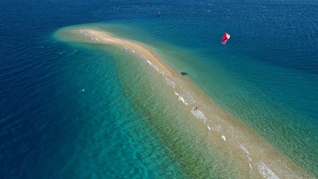 Aerial drone photo of kite surfer practising in tropical exotic sandbar part of island Atoll with turquoise and emerald open ocean sea