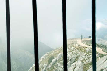 Beautiful view of the mountains in the fog through the bars. Think of freedom. Montenegro