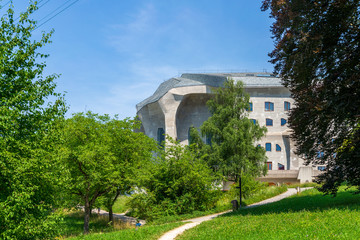 Fototapeta na wymiar Outdoor exterior sunny view of Goetheanum, sculptural expressionist cast concrete architecture designed by Rudolf Steiner, at School of Spiritual Science in Dornach, Switzerland.