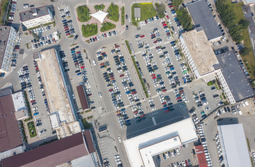 huge Parking lot in center of the business district, top view from the drone with car parking around as sense of community and neighborhood.