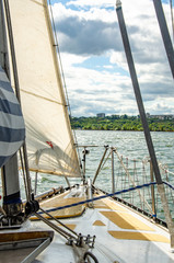Fototapeta premium The bow of a sailing boat amid waves and an approaching shore