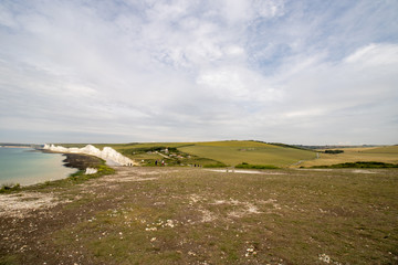 The famous Seven Sisters chalk cliffs by the English Channel. They form part of the South Downs in East Sussex, between the towns of Seaford and Eastbourne in southern England, taken on a bright day.