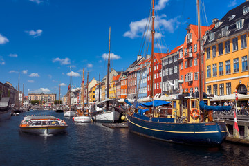 Sightseeing boat sailing by the harbour Nyhavn of Copenhagen