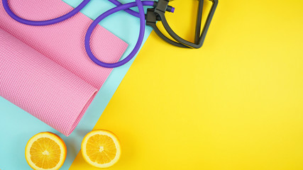 Health and fitness concept flatlay with exercise equipment on modern colorful background with copy...