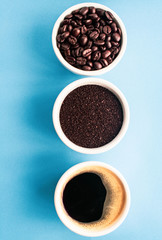 cup of coffee with beans on blue background