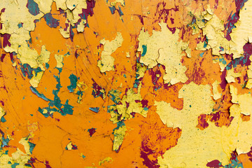 rusty metal sheet with peeling layers of paint of different colours - a surface texture photo