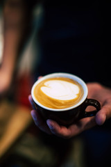 cup of cappuccino in hands