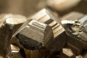 Macro closeup of pyrite mineral with mirror-bright, golden striated cubes