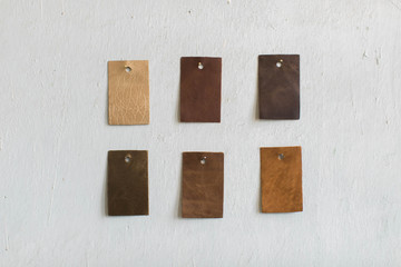 Leather Cowhide Swatches hanging on wall, copy space, purse and bag leather samples