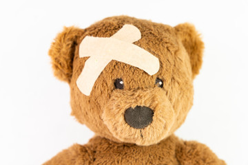 Childhood illness and sick kids concept with a adhesive bandages on its head to cover an injury with copy space 