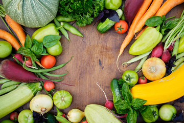 Fresh Harvest from the Gardens on Wooden chalkboard from above. Carrot, tomato, pepper, cucumber, onion, zucchini, radish, parsley.