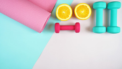 Health and fitness concept flatlay with exercise equipment on modern colorful background with copy space.