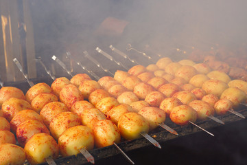  Potatoes on the grill. Cooking street food. Potato tubers are fried over an open fire