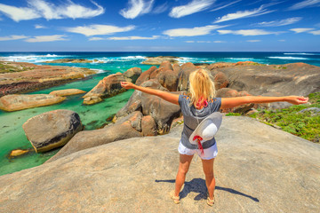 Happy woman on the cliffs above elephant-shaped rocks of Elephant Rocks in Western Australia. Young girl looking Great Southern Ocean in William Bay NP. Summer destination in Australia, Albany Region.