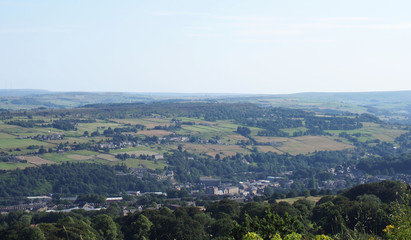 Fototapeta na wymiar a panoramic view of the countryside around sowerby bridge in west yorkshire with buildings of the town surrounded by farms and fields in a pennine landscape