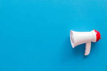 Attract attention with megaphone on blue background top view copyspace
