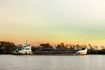 Fototapeta na wymiar Sand extractor Ship sailing on the Parana River at Sunset,