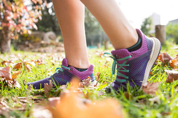 Woman wearing sport shoes doing exercise outdoors at autumn