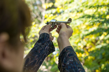 Mature Woman holding Airplane Tin Toy imagining Travel Outdoors