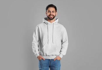 Portrait of young man in sweater on grey background. Mock up for design