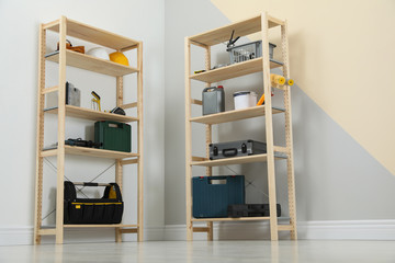 Wooden shelving units with different instruments near color wall. Stylish room interior
