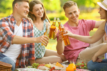 Young people enjoying picnic in park on summer day
