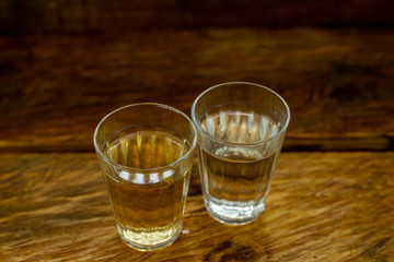 Several glasses of brazilian cachaça isolated on rustic wooden background, variations and types of brazil cachaça, typical drink from brazil.