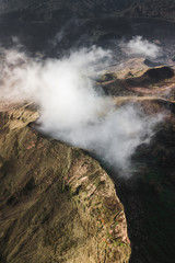 Aerial view of Batur volcano caldera in Bali. Volcanic black texture and crater rim, view from above, drone shot