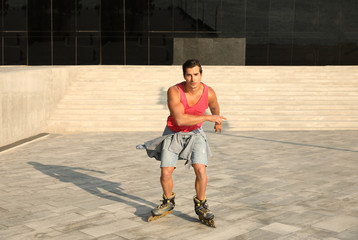 Handsome young man roller skating on city street